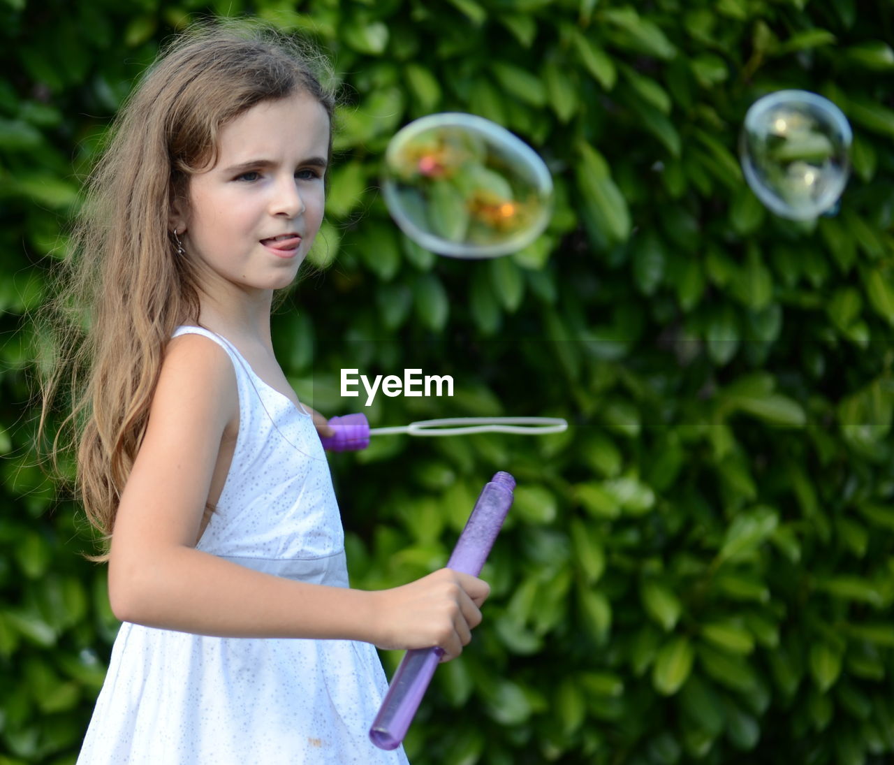 Portrait of girl playing with bubble wand