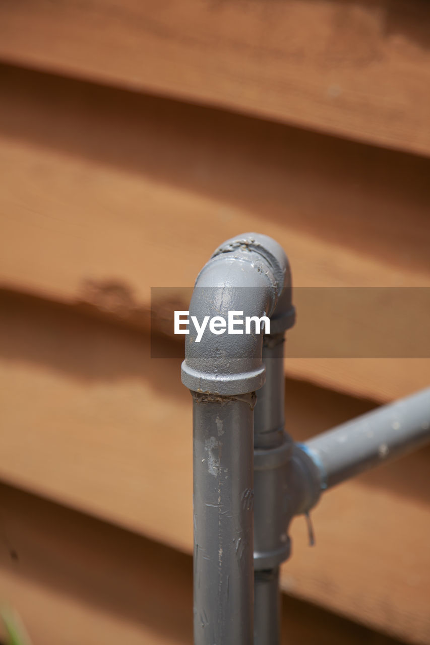 Close up of metal plumbing pipe leading into a home