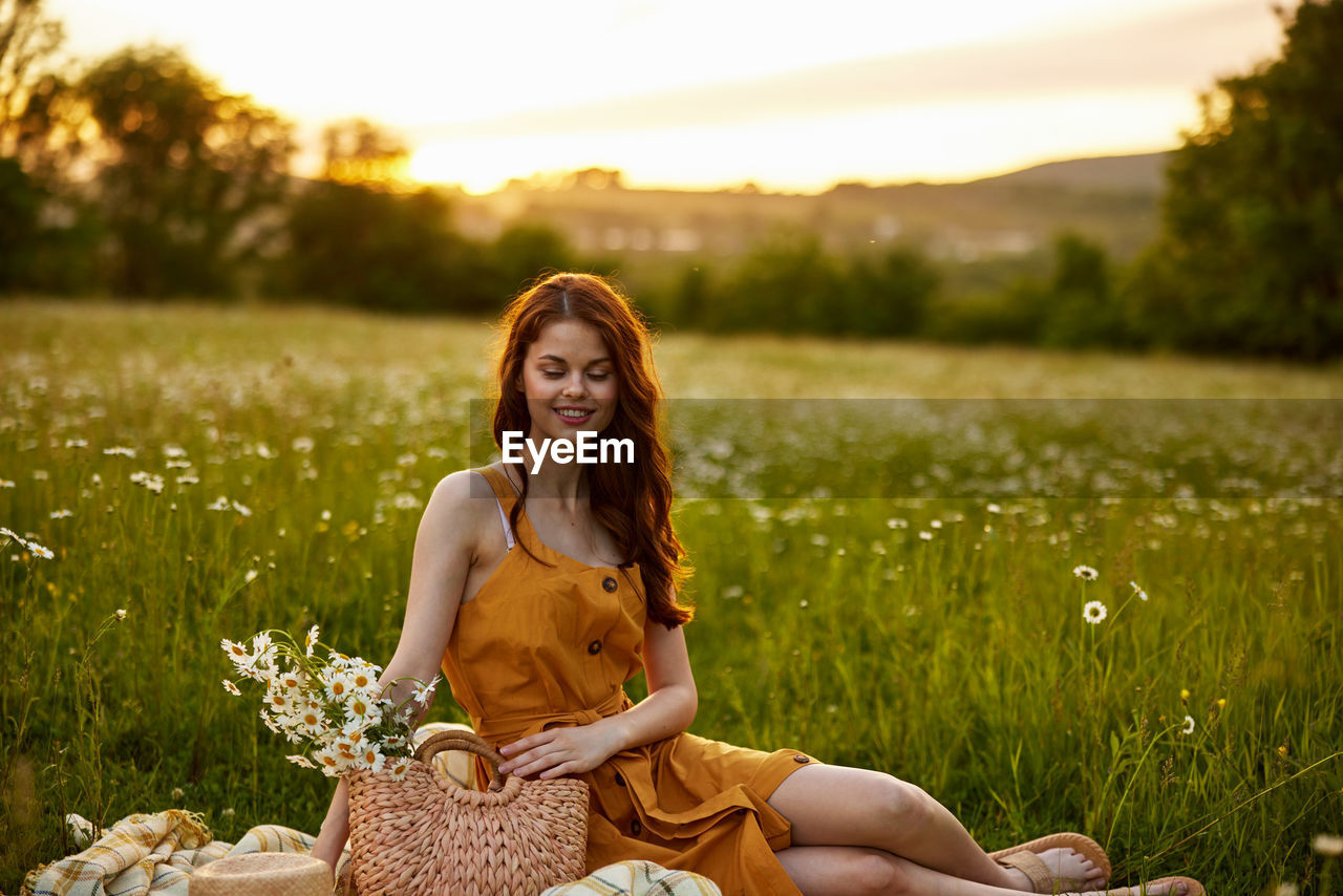 portrait of young woman sitting on grassy field