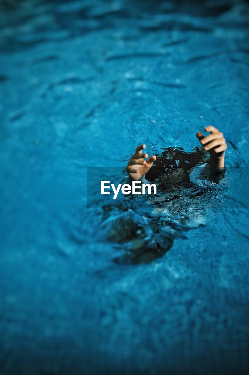 High angle view of woman drowning in swimming pool