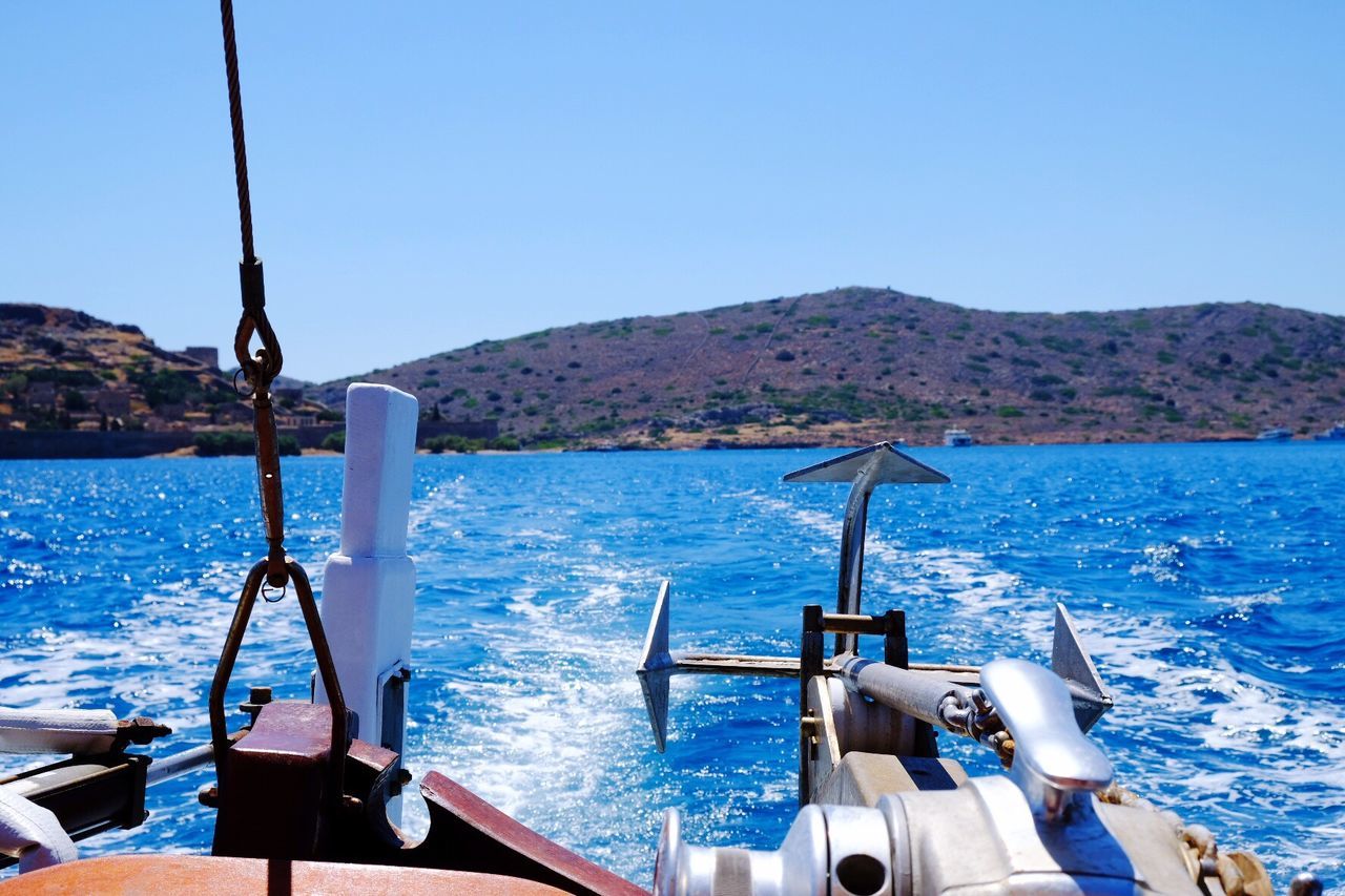 Boat sailing in sea against clear sky