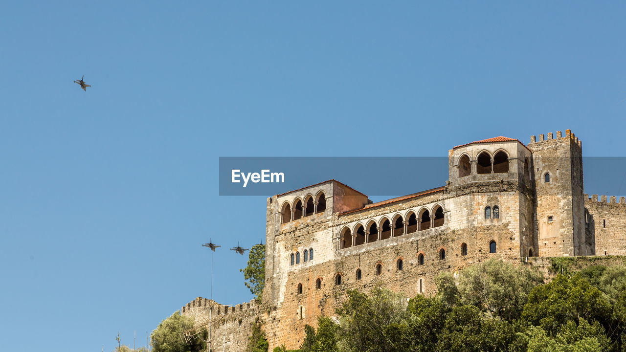 LOW ANGLE VIEW OF HISTORIC BUILDING AGAINST BLUE SKY