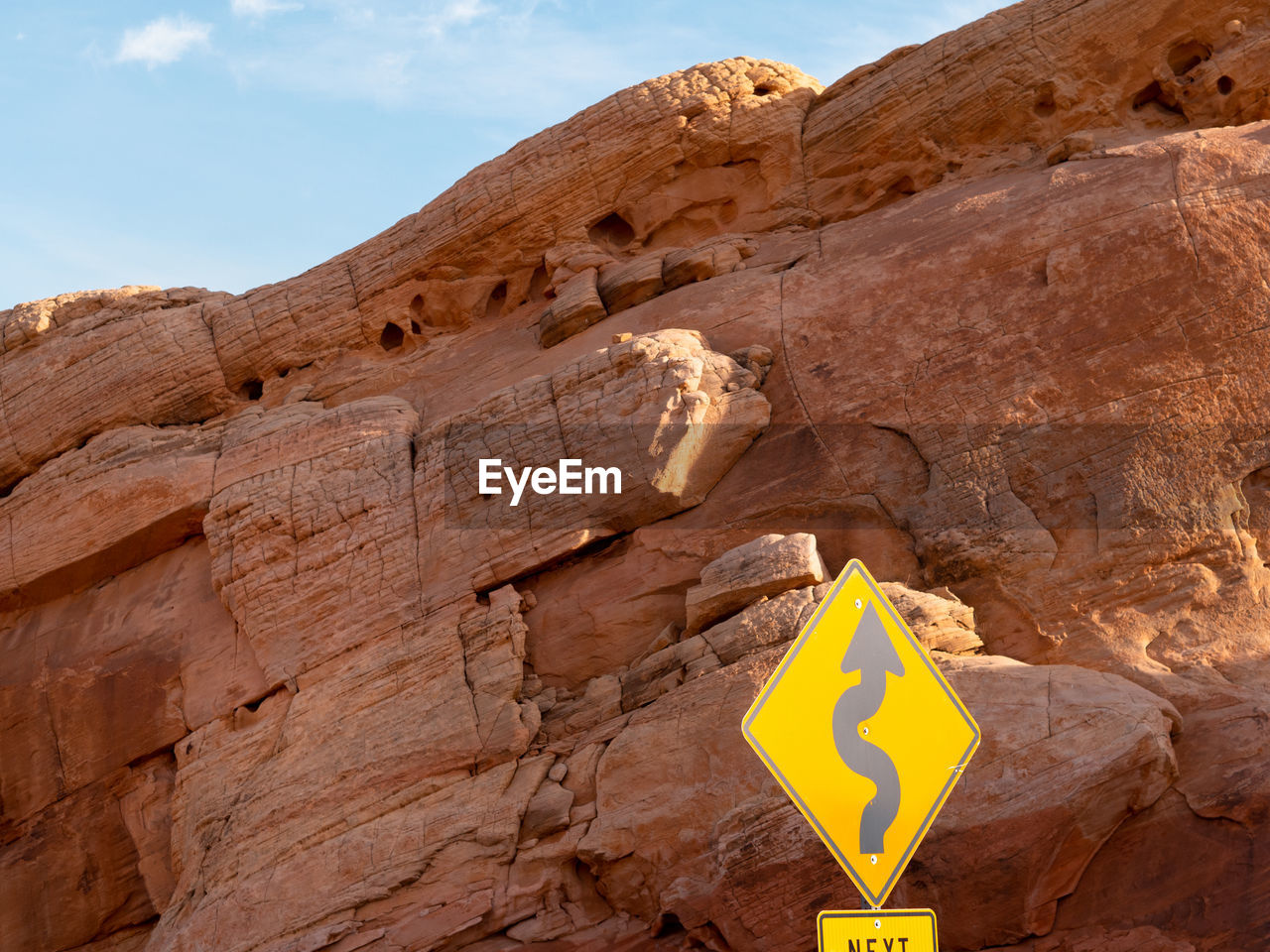 LOW ANGLE VIEW OF SIGNBOARD AGAINST ROCK