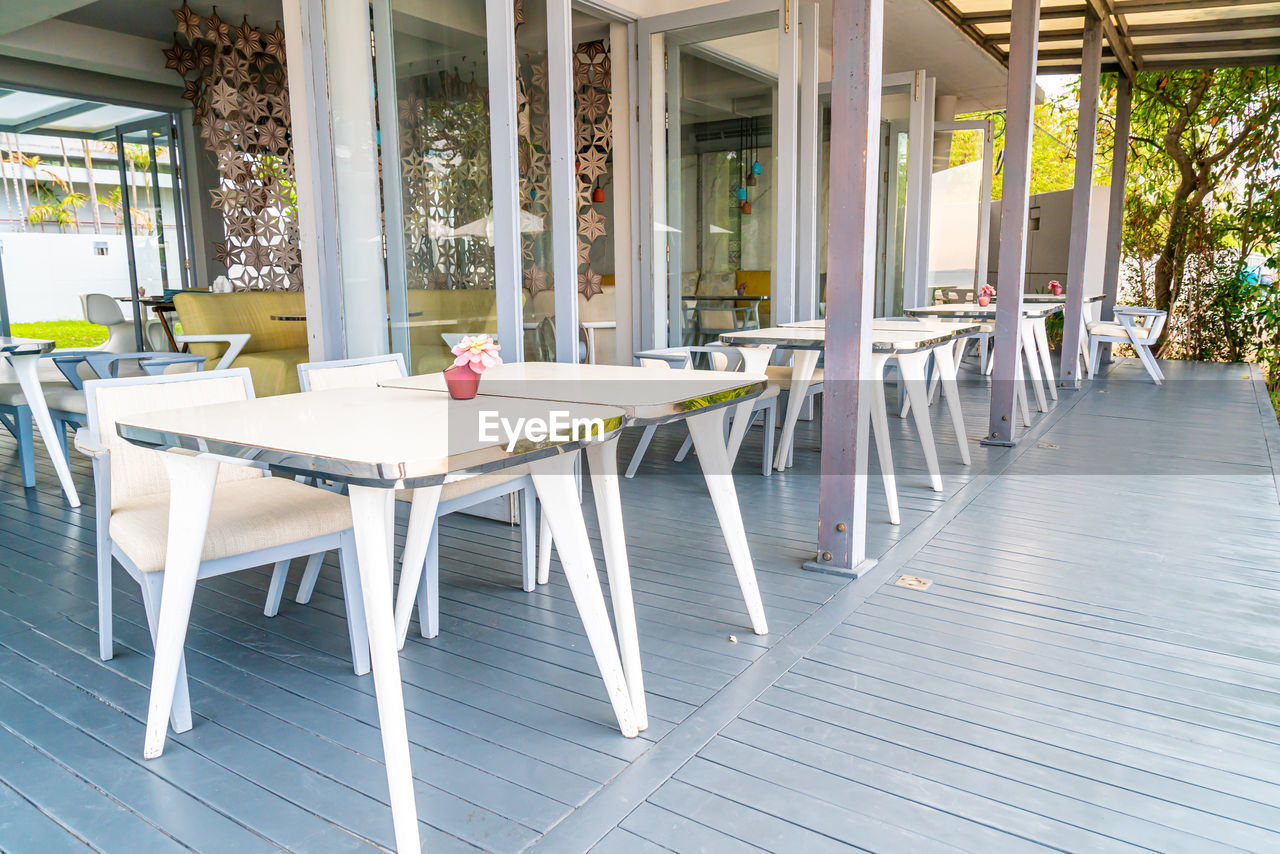 EMPTY CHAIRS AND TABLES AT SIDEWALK CAFE