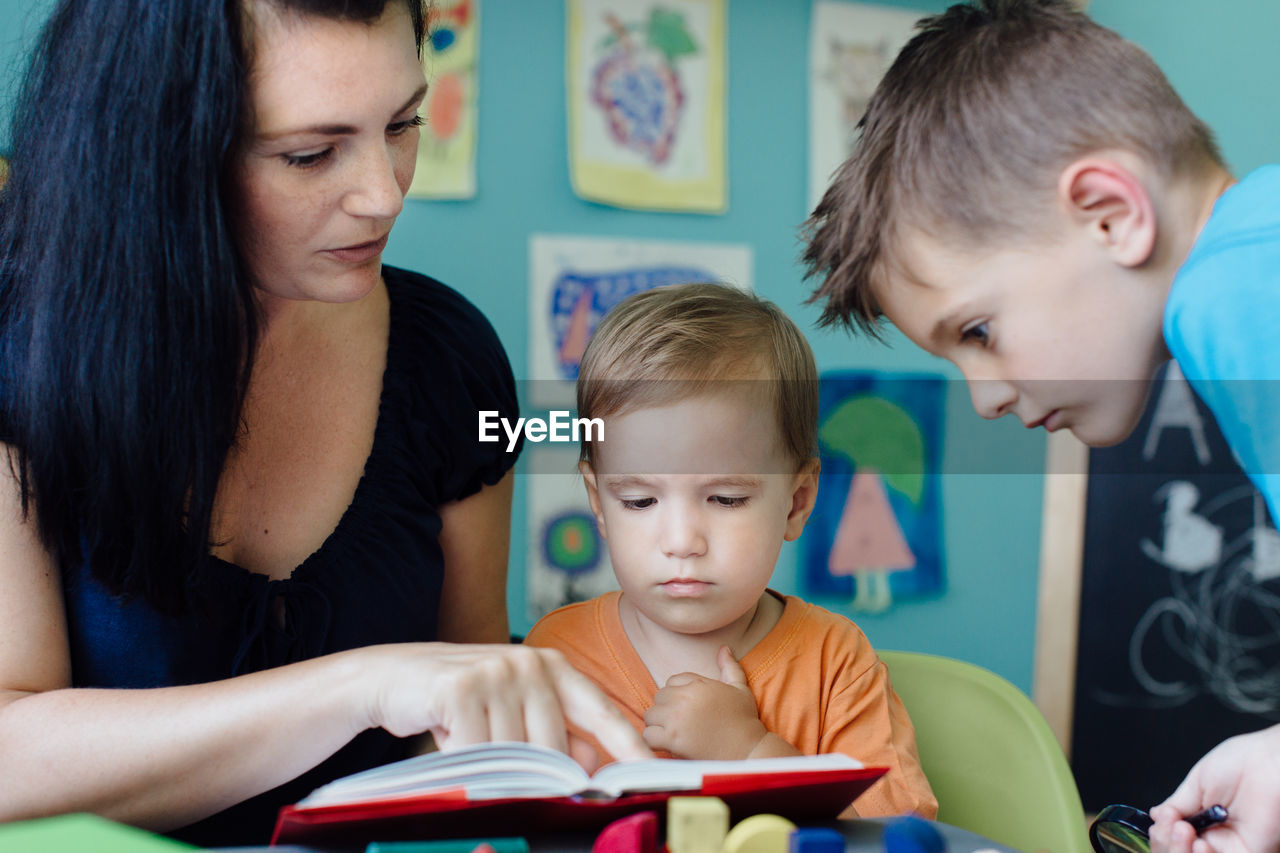 Siblings looking at book