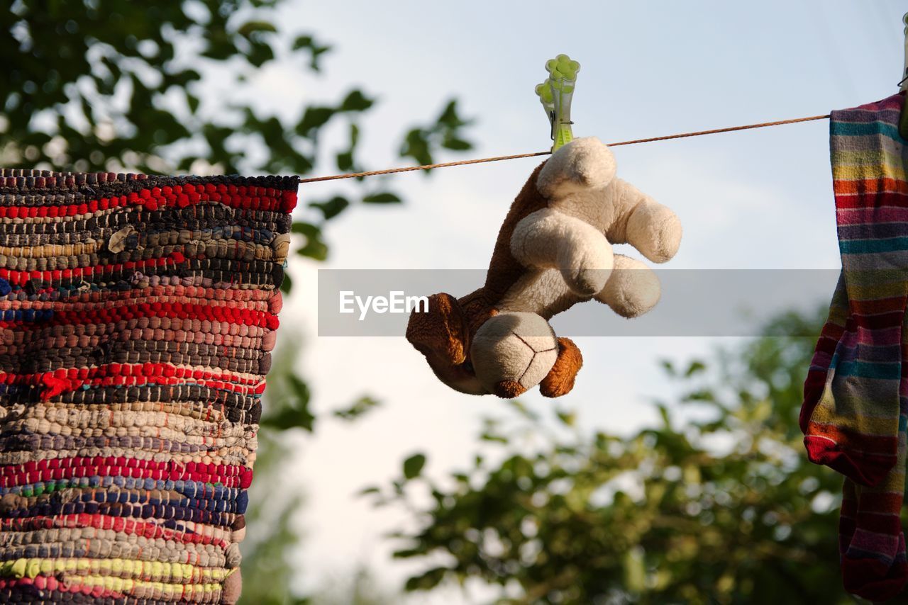 Low angle view of laundry hanging on rope against sky