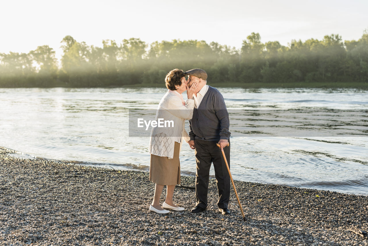 Happy senior couple kissing on the beach