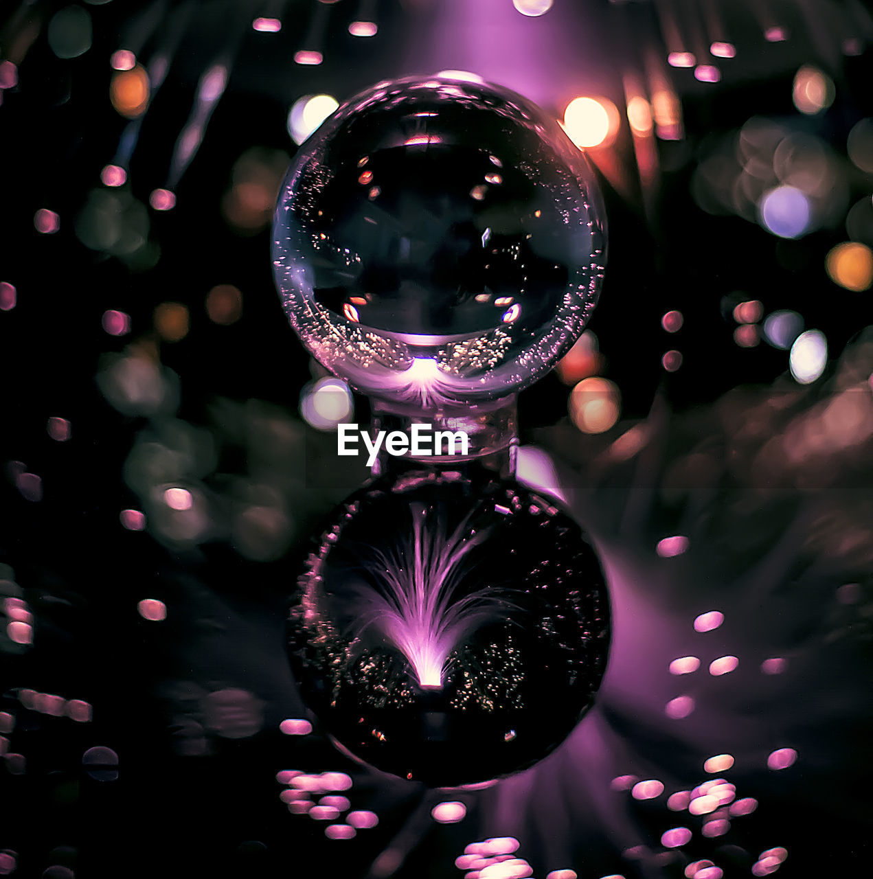Crystal ball on table with reflection of firework display