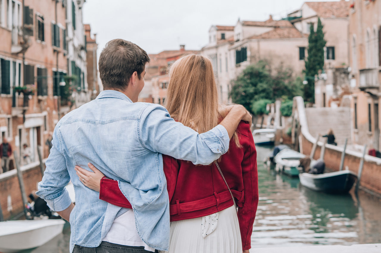 Couple standing against canal in city