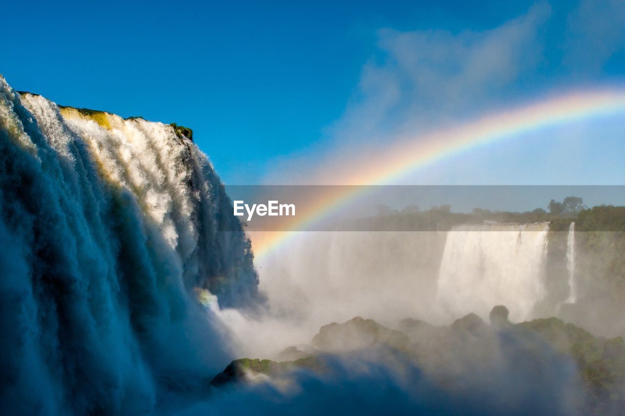 Scenic view of rainbow above iguazu falls