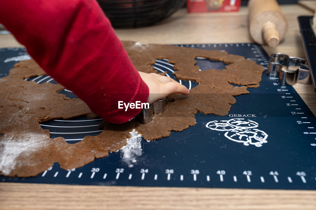 cropped hands of person preparing gingerbread cookies