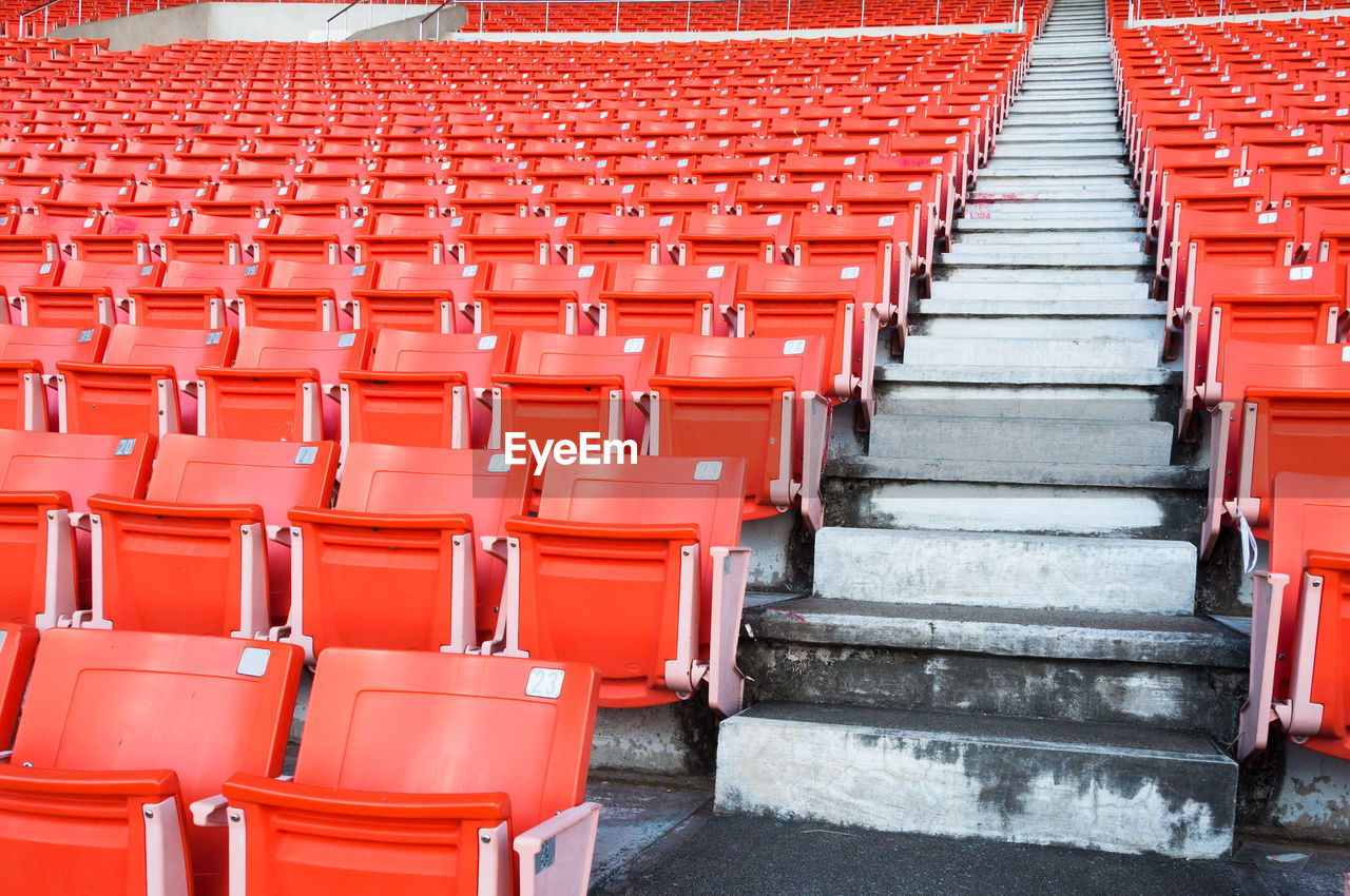 Empty orange seats at stadium,rows walkway of seat on a soccer stadium