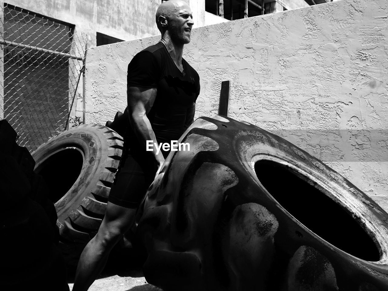 Man exercising with large tire