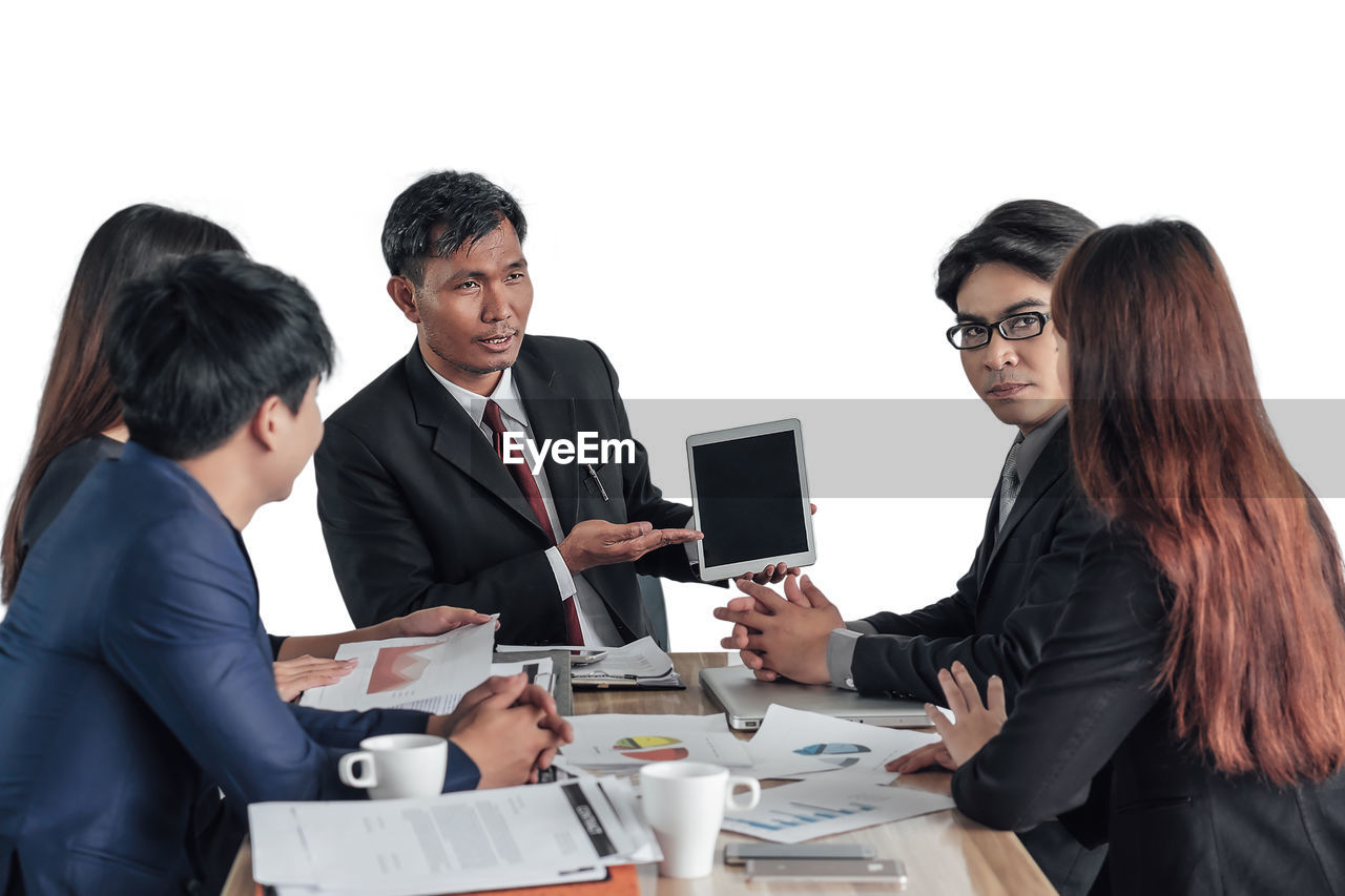 Business people at desk against white background