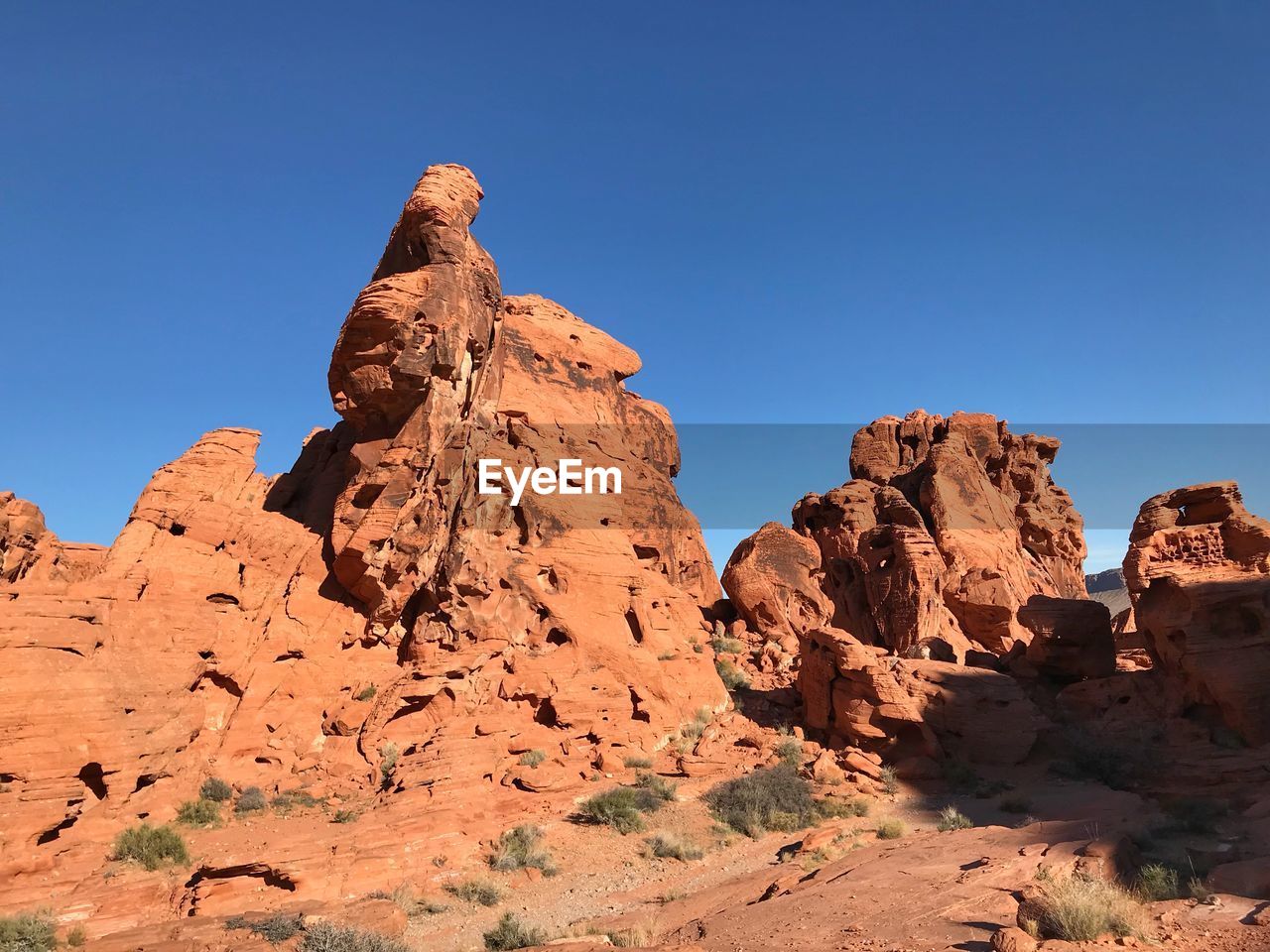 Low angle view of rock formation against clear blue sky