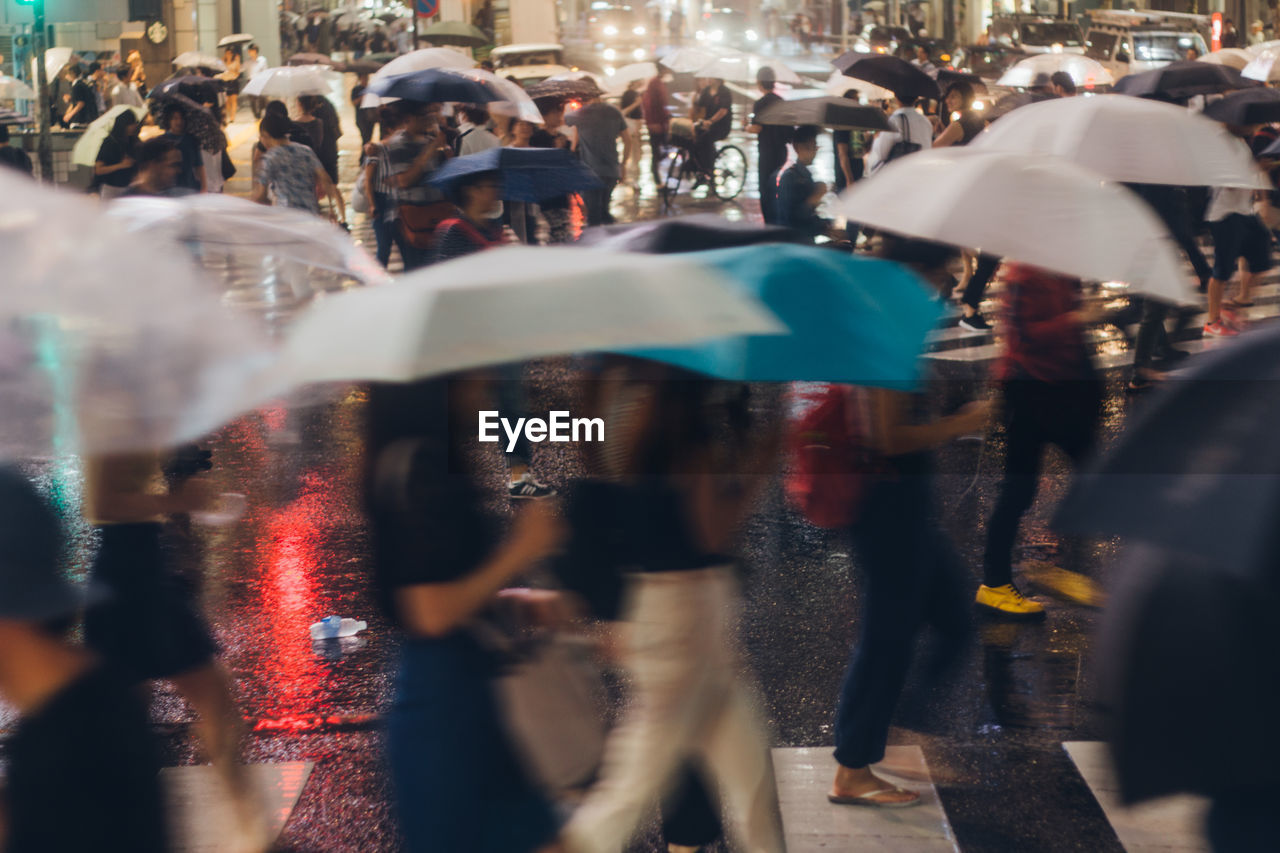 People walking with umbrella on street at night