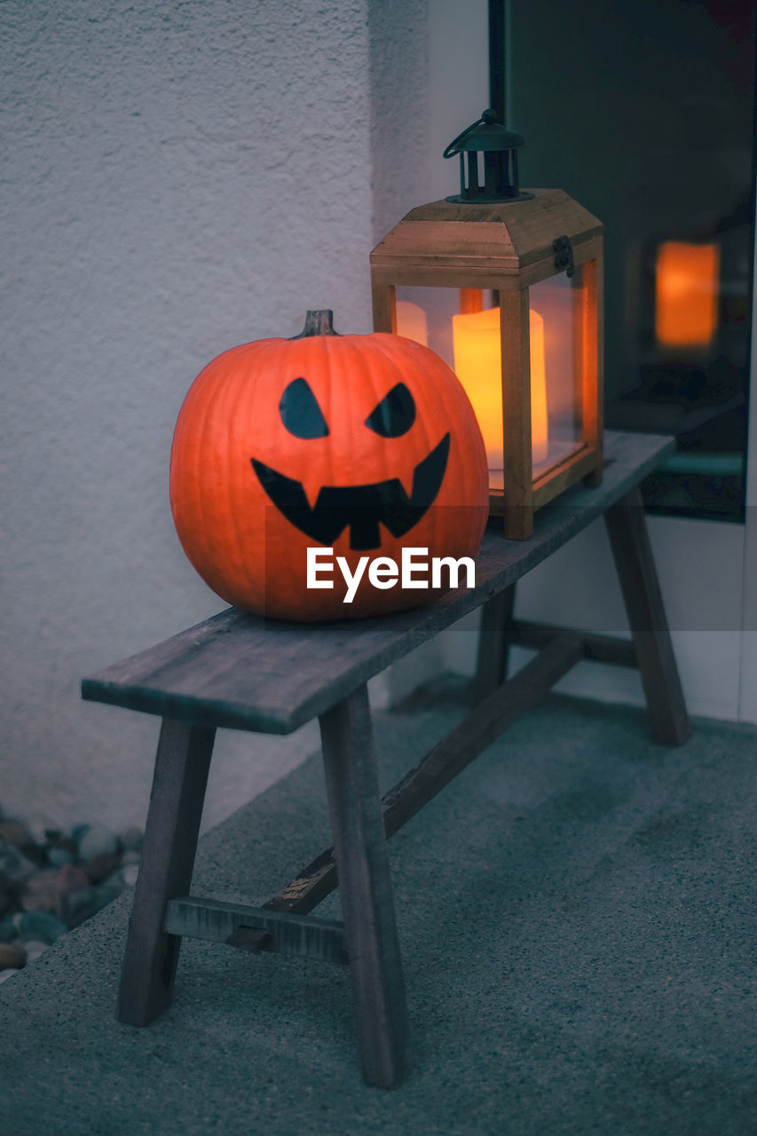 View of pumpkin on wooden bench at home during halloween
