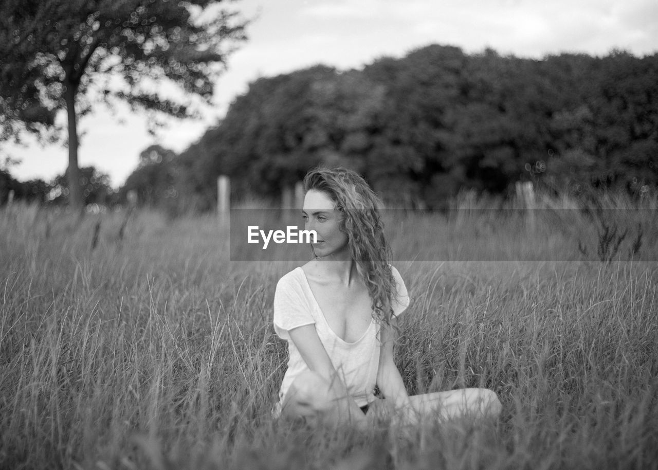 Seductive woman sitting on field