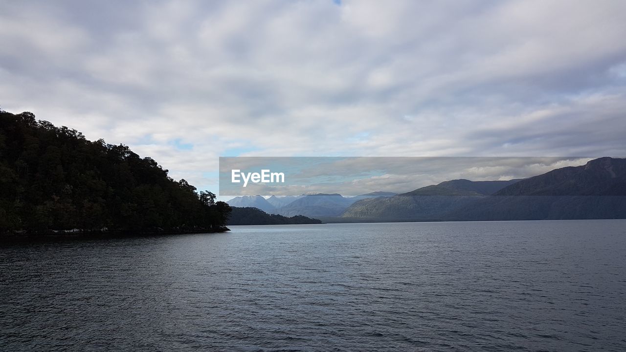 Scenic view of sea and mountains against sky