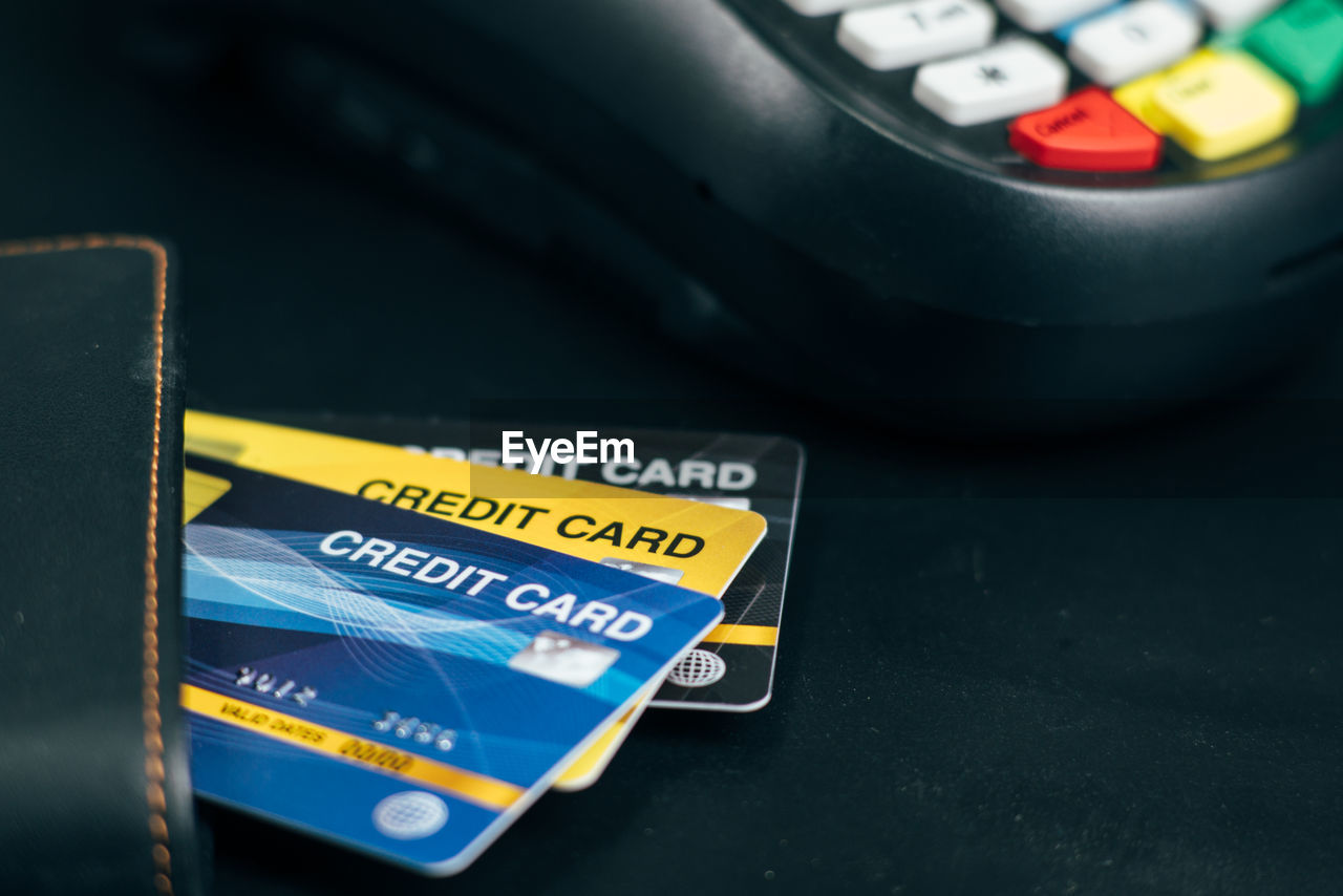 High angle view of credit cards in wallet by reader on table