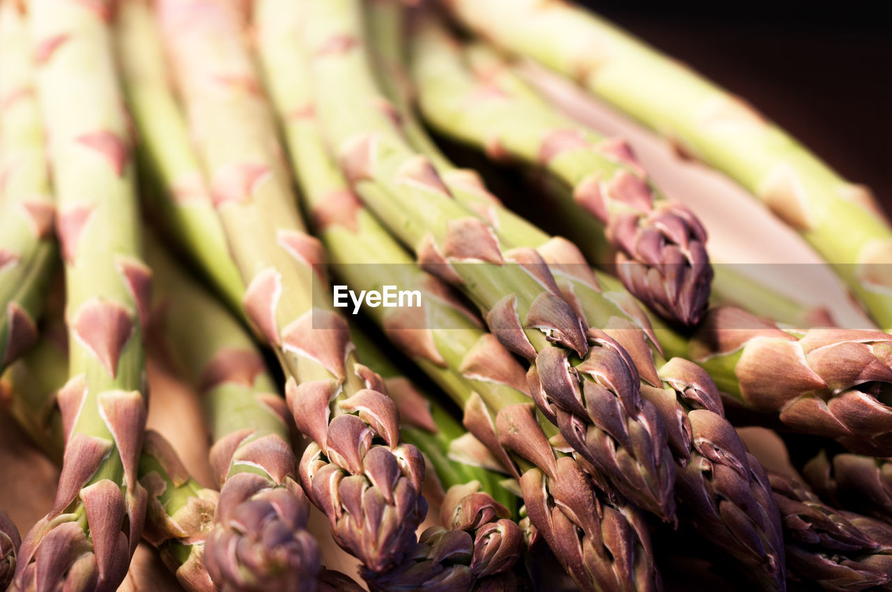 Many asparagus on a wooden base and on a black background. healthy vegetable food. studio shoot