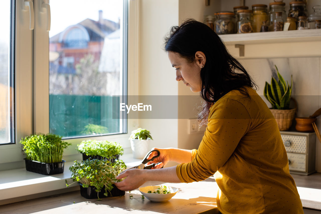 Side view of young woman at home