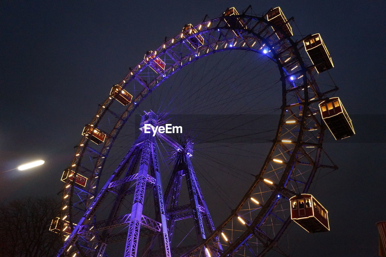 Low angle view of ferris wheel at night