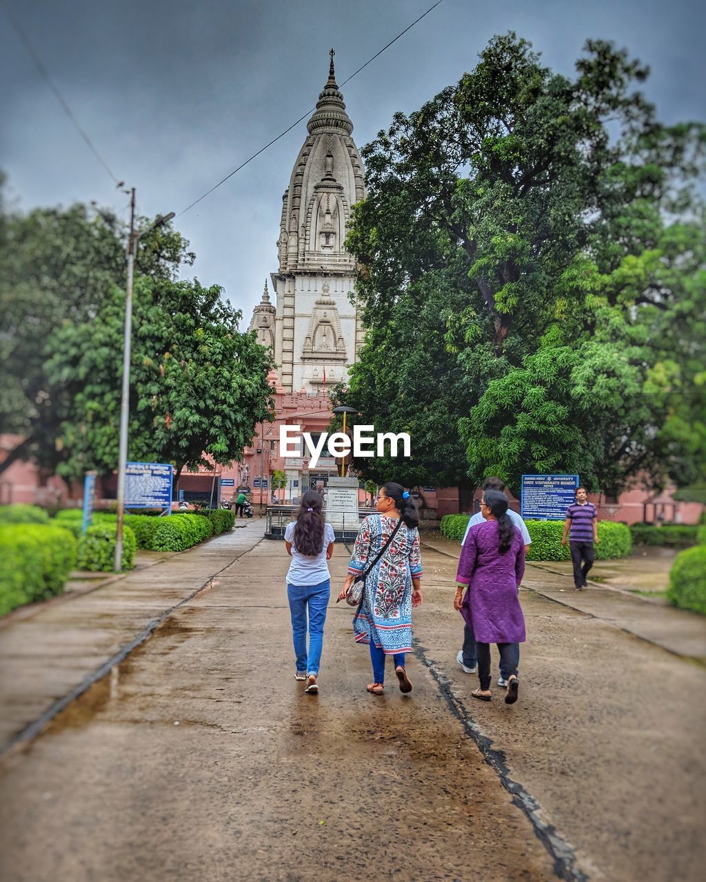 Rear view of people walking on footpath