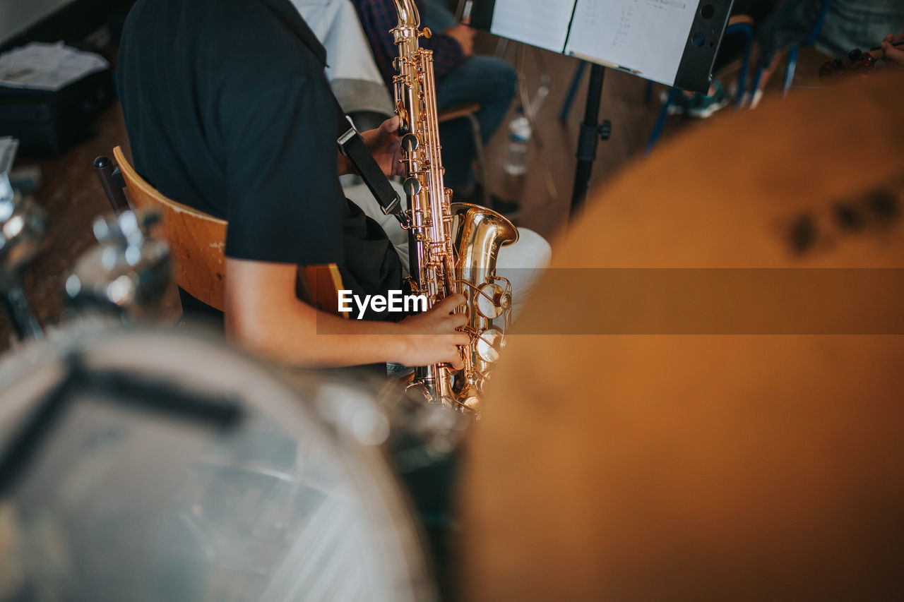 Midsection of man playing saxophone