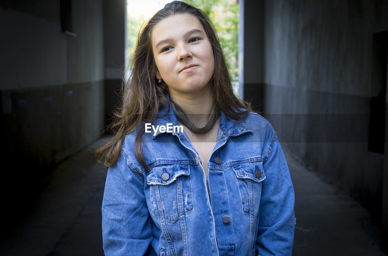 Close-up portrait of teenage girl in corridor