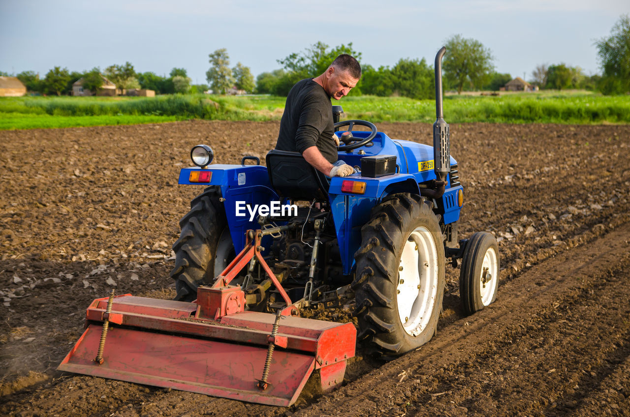 Kherson oblast, ukraine - may 29, 2021. senior farmer works in the field on a tractor
