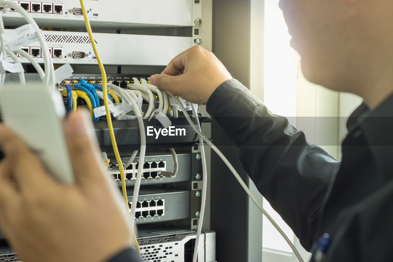 Cropped image of man connecting usb plug on network server