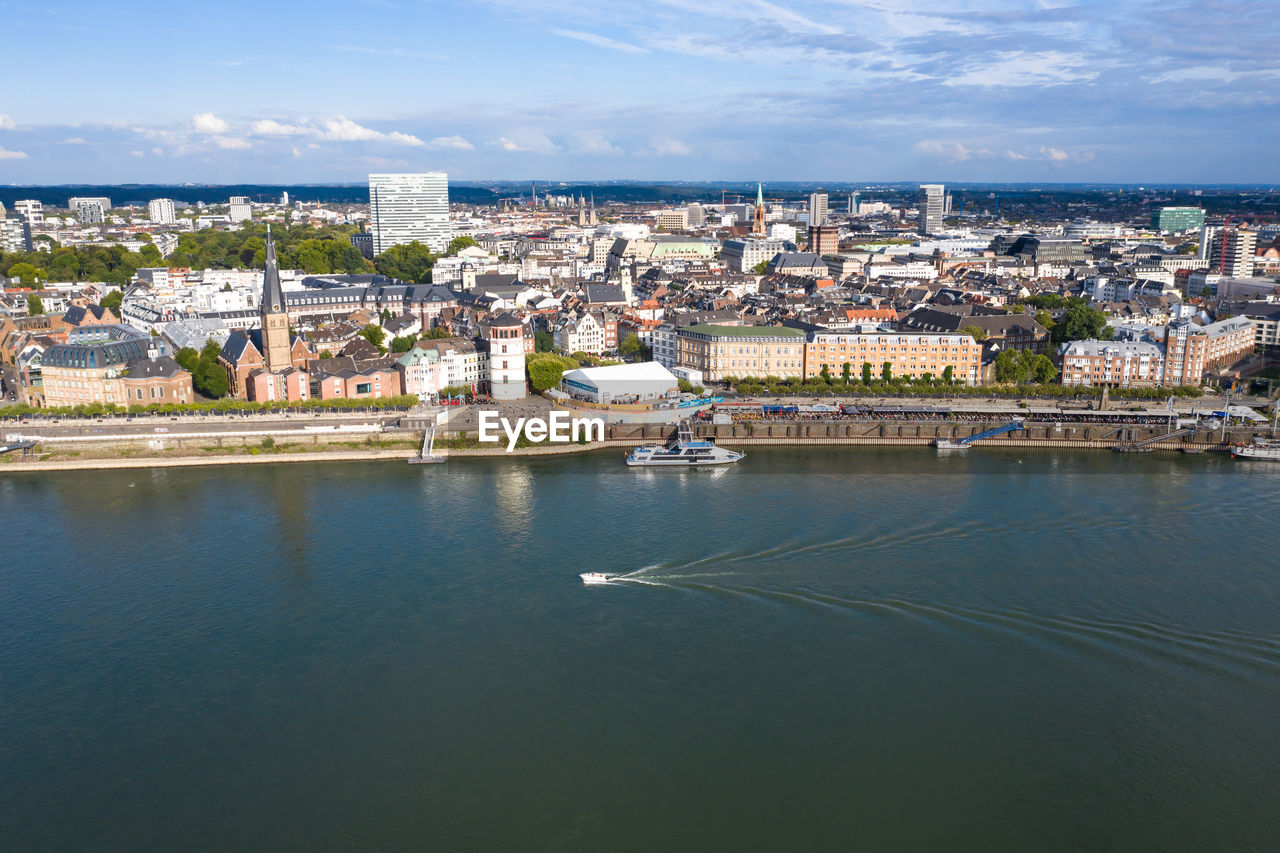 HIGH ANGLE VIEW OF TOWNSCAPE AND SEA AGAINST SKY