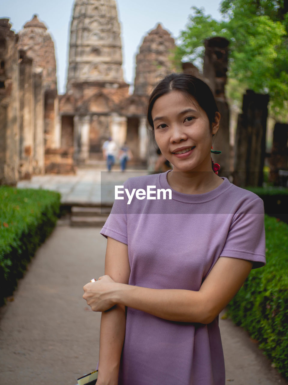 Portrait of smiling woman standing against building