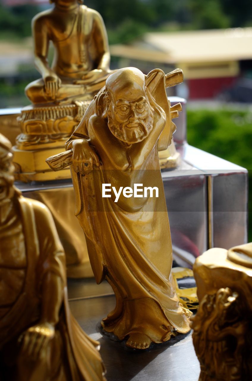 CLOSE-UP OF BUDDHA STATUE OUTDOORS