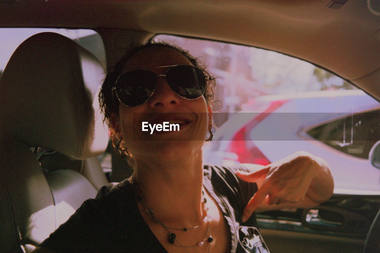 CLOSE-UP OF MAN WEARING SUNGLASSES IN CAR