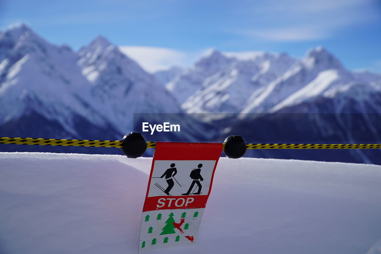 INFORMATION SIGN AGAINST SNOWCAPPED MOUNTAINS DURING WINTER