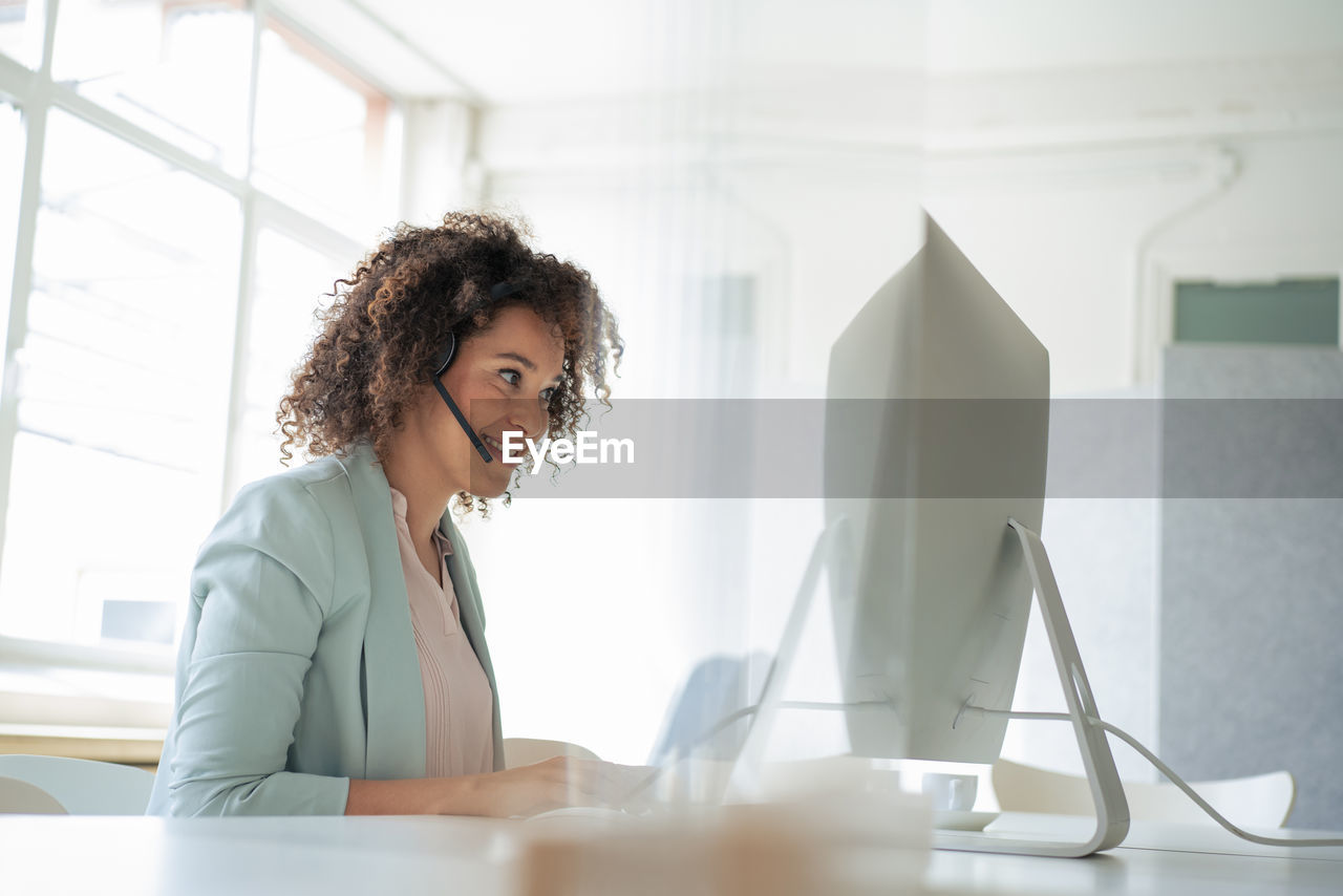 Smiling businesswoman working on computer in office