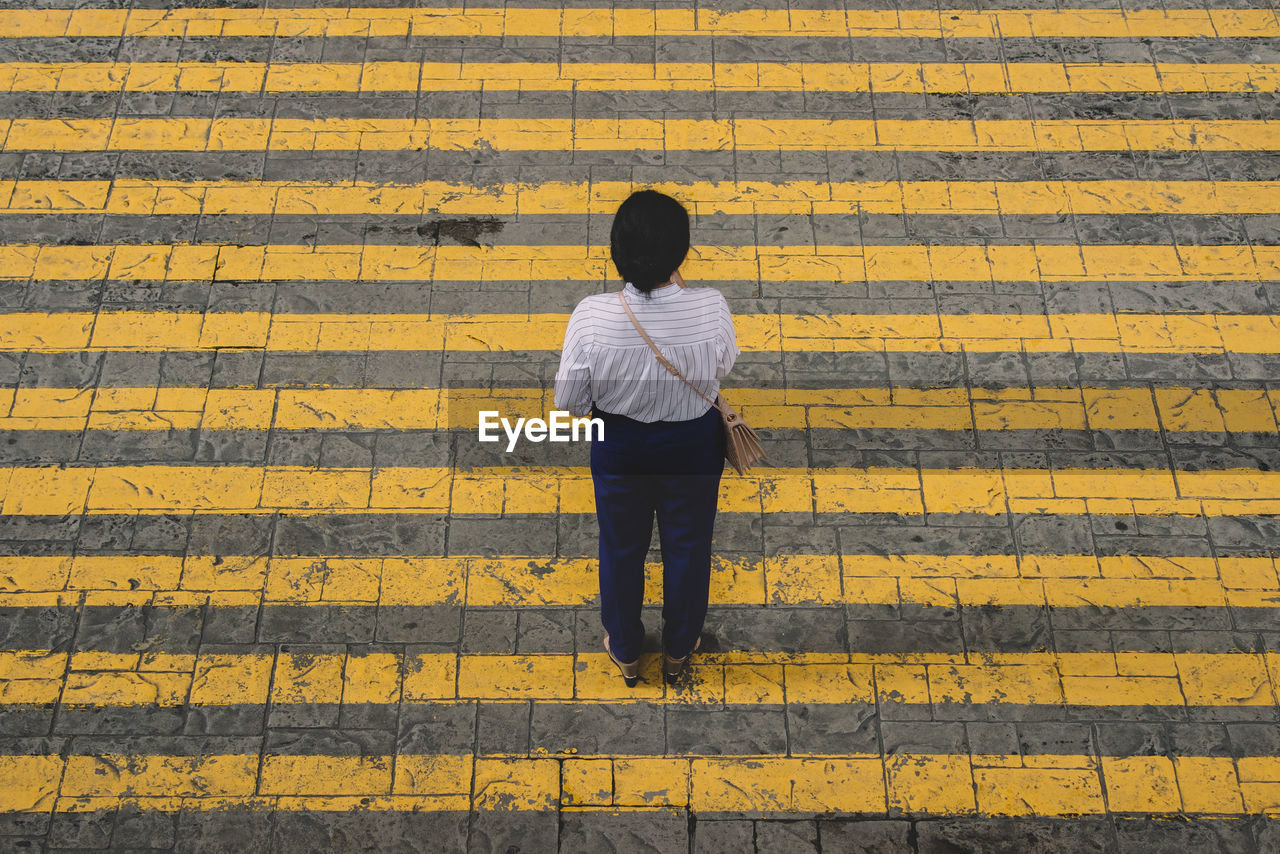 Rear view of man walking on road