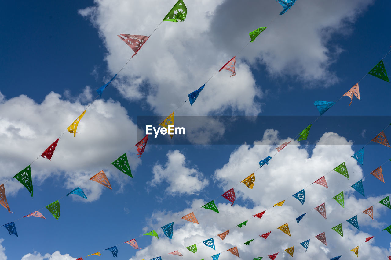 Low angle view of flags hanging against sky