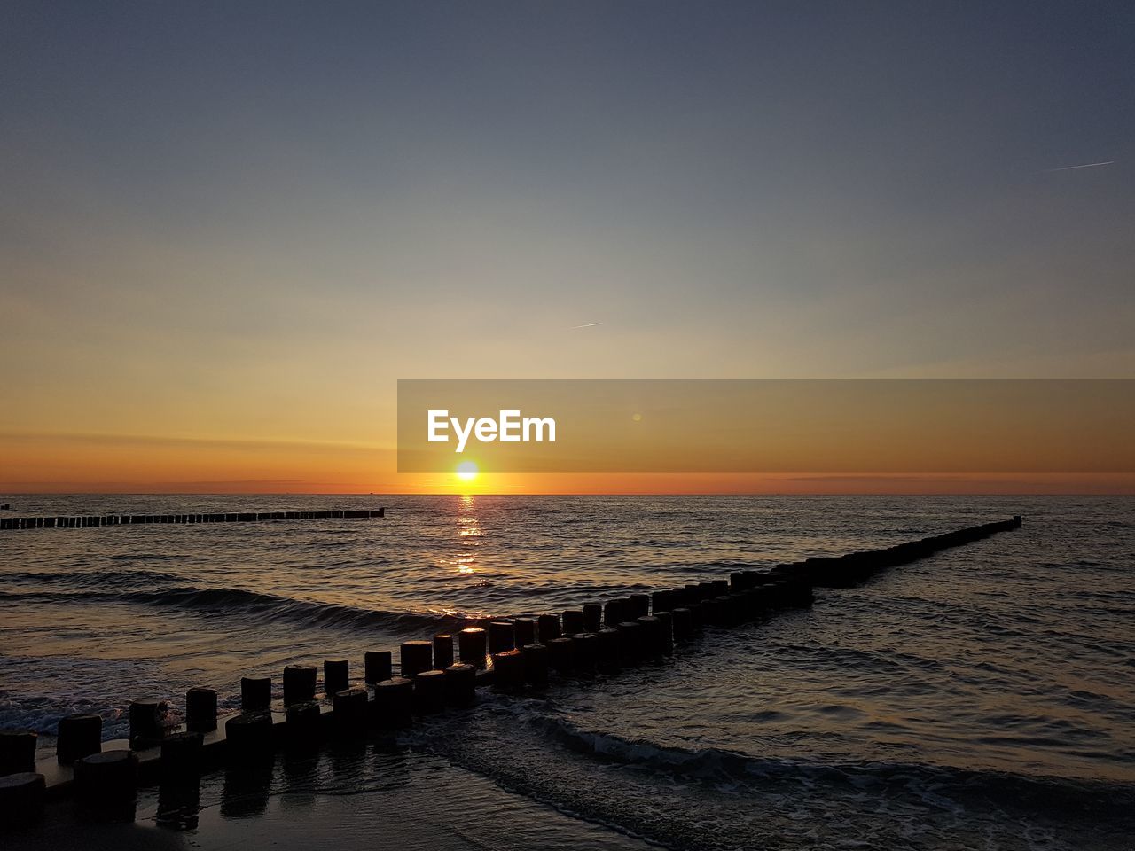 SCENIC VIEW OF BEACH AGAINST SKY DURING SUNSET