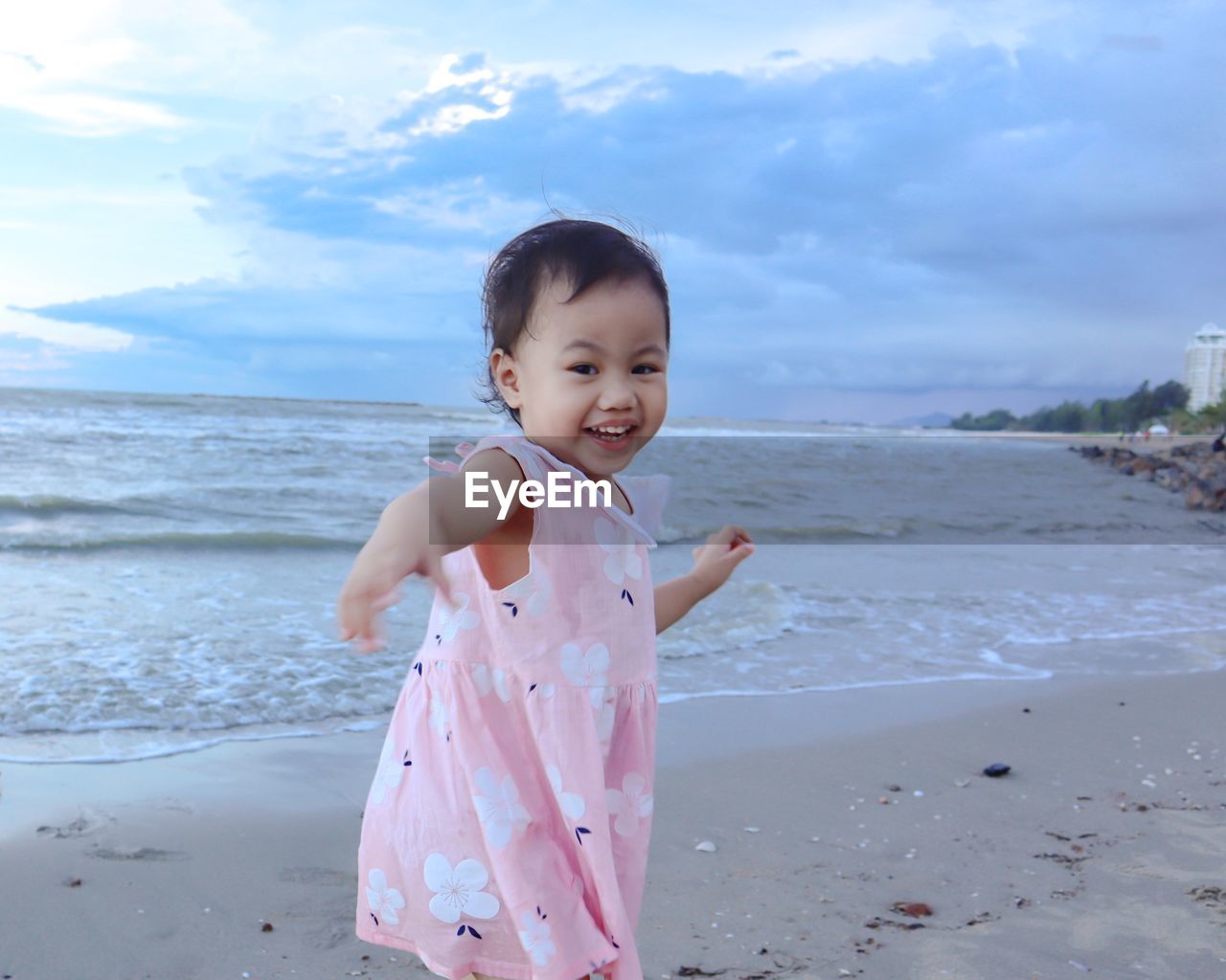 Cute girl at beach against sky