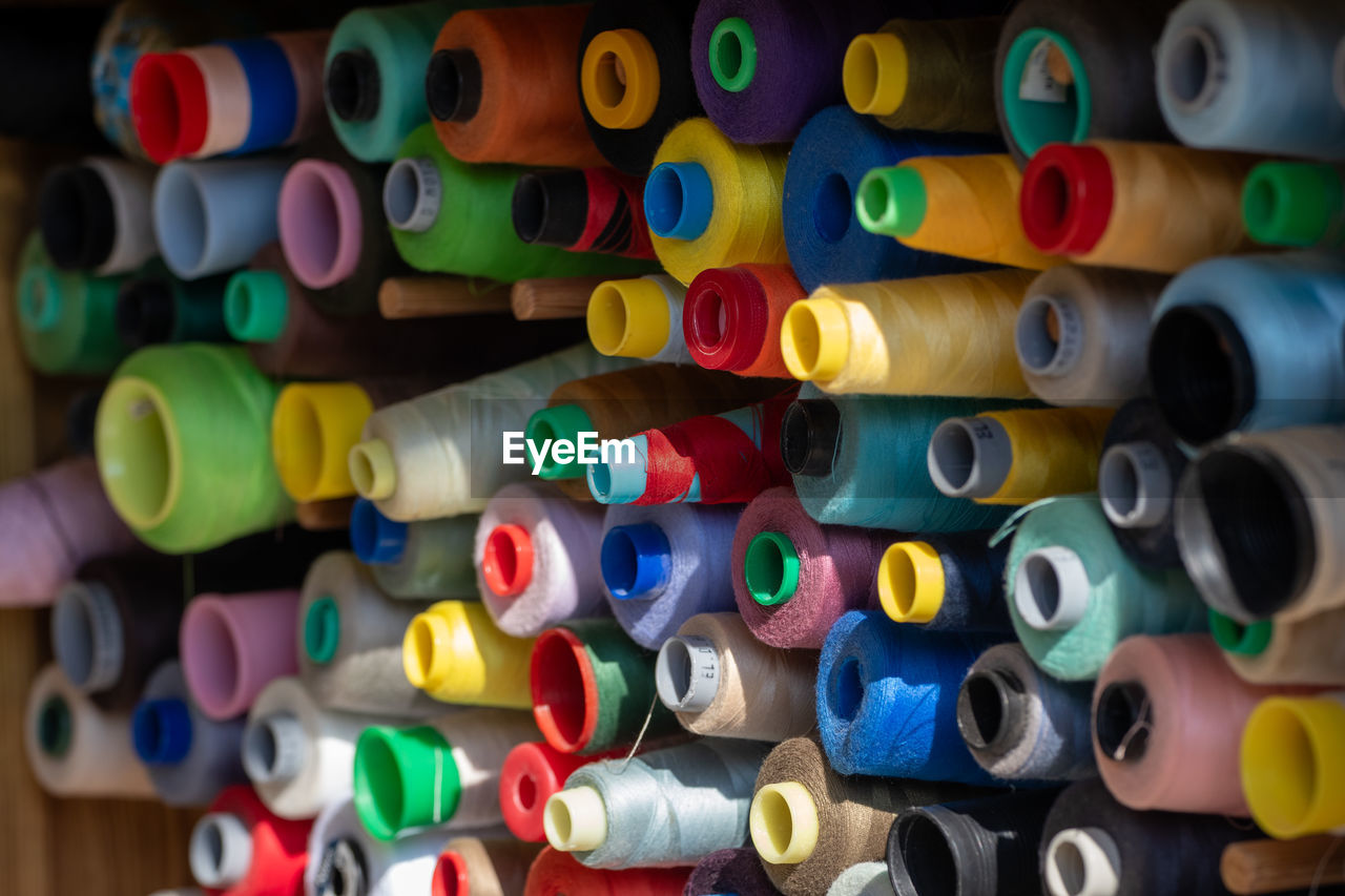 multi colored, large group of objects, spool, variation, abundance, thread, art, no people, indoors, in a row, textile industry, sewing item, green, backgrounds, full frame, close-up, yellow, textile, still life