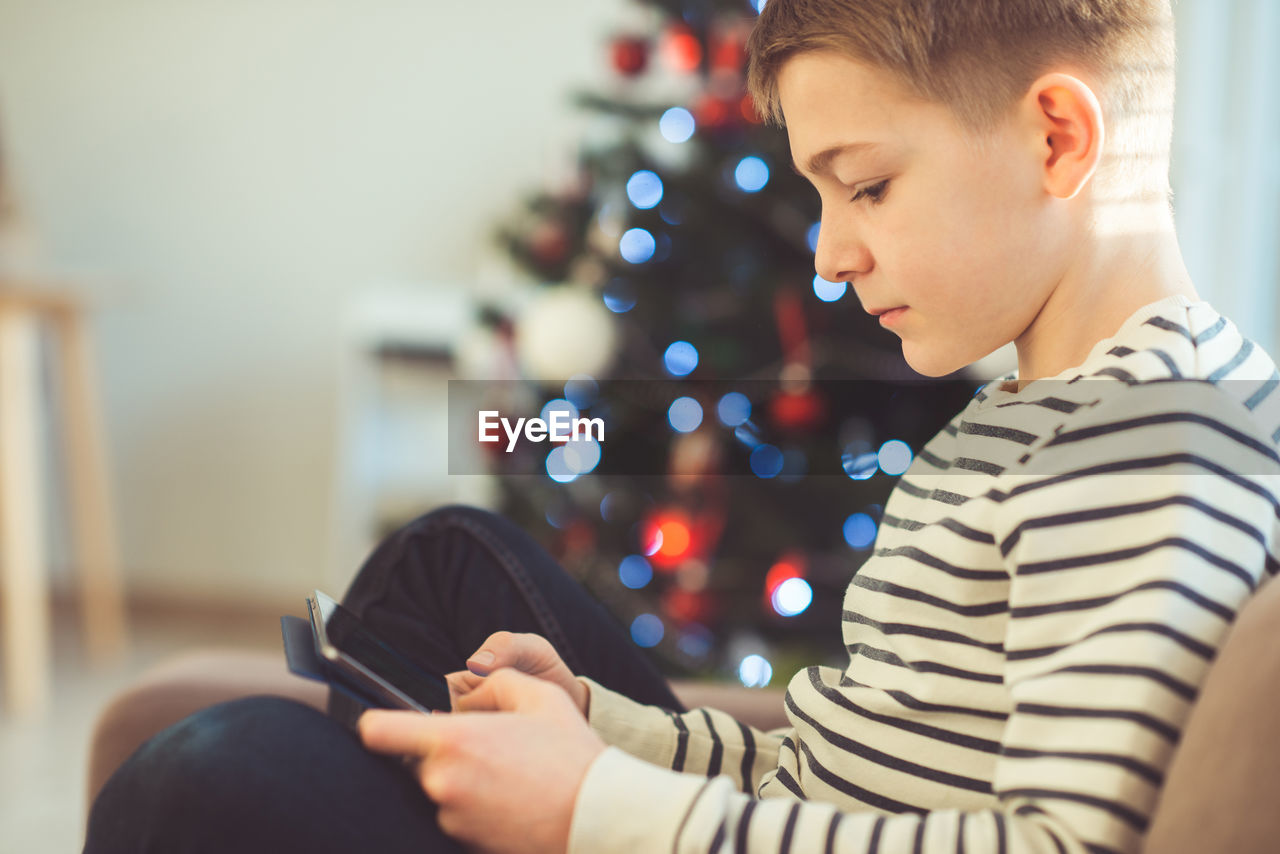 Boy using digital tablet at home during christmas