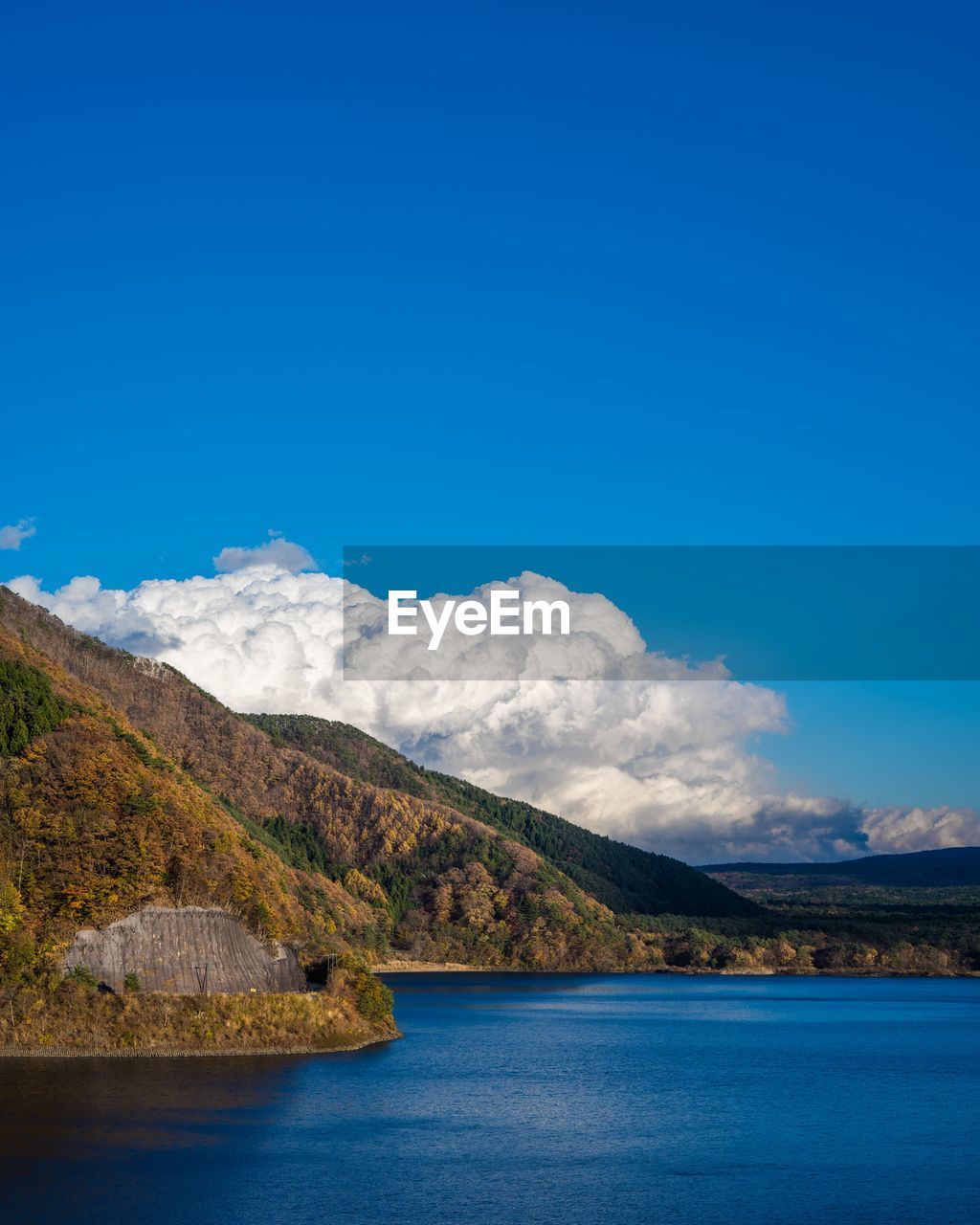 Scenic view of lake and mountains against blue sky