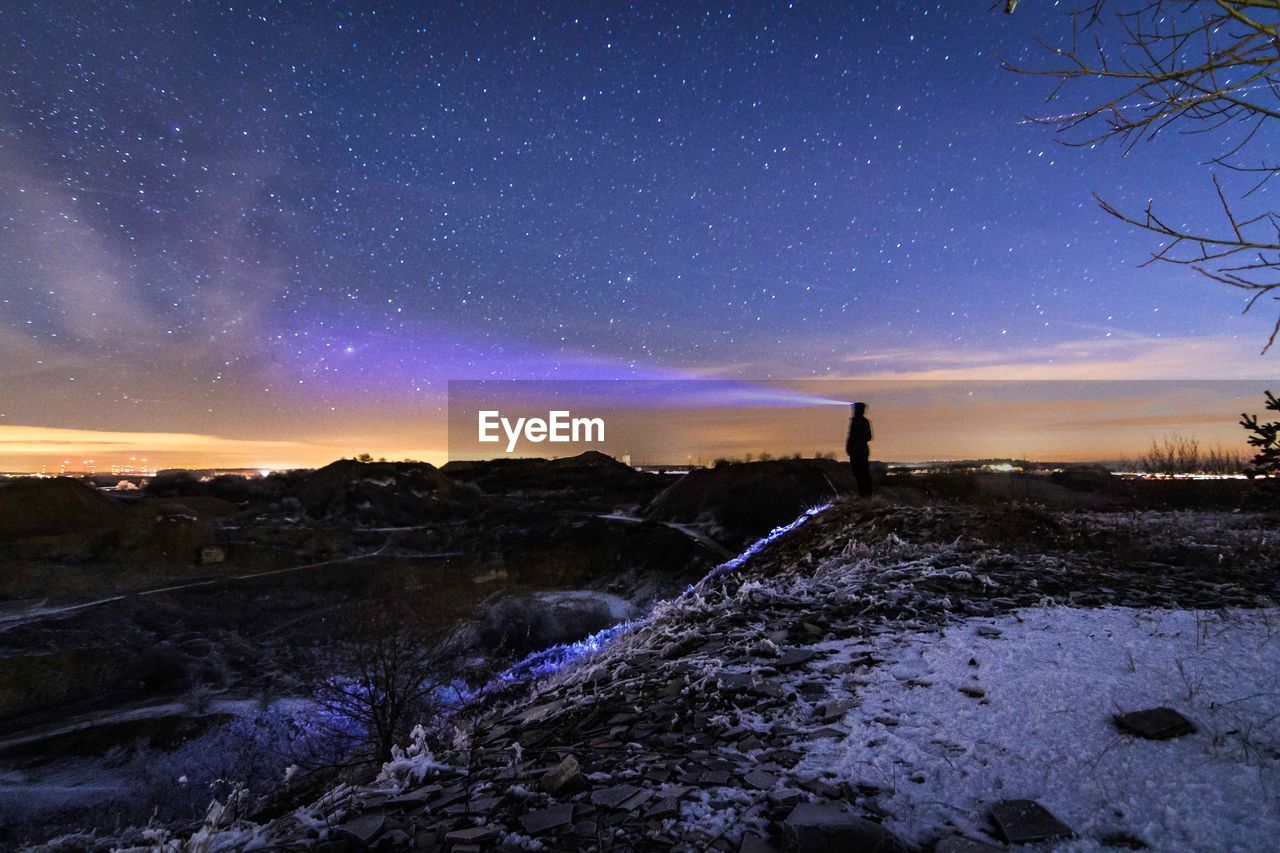 Scenic view of snow covered landscape against sky at night