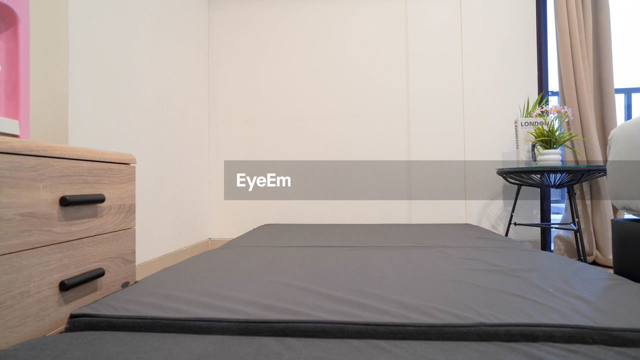 furniture, indoors, room, chest of drawers, home interior, domestic room, bed, table, drawer, no people, bedroom, office, business, floor, window, desk, nightstand, luxury, home showcase interior, seat, lifestyles, architecture, wealth, filing cabinet, domestic life, absence, chair