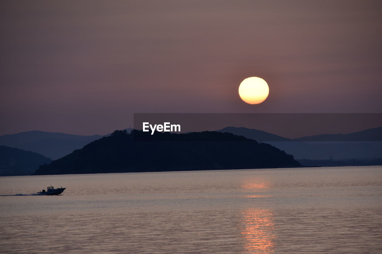 SCENIC VIEW OF SEA AGAINST ORANGE SKY