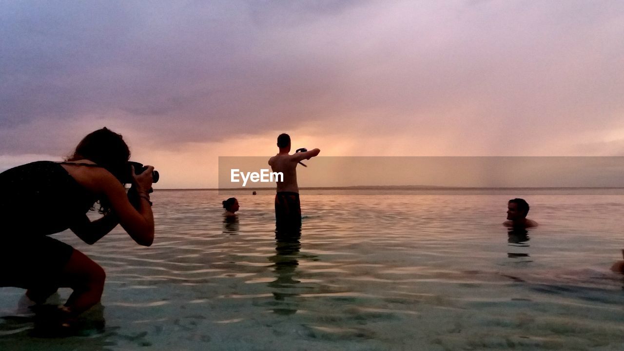 TWO PEOPLE PLAYING ON BEACH