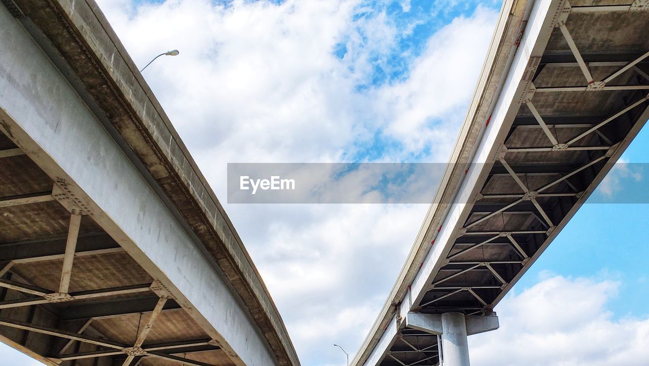 LOW ANGLE VIEW OF BRIDGE AGAINST BUILDINGS IN CITY